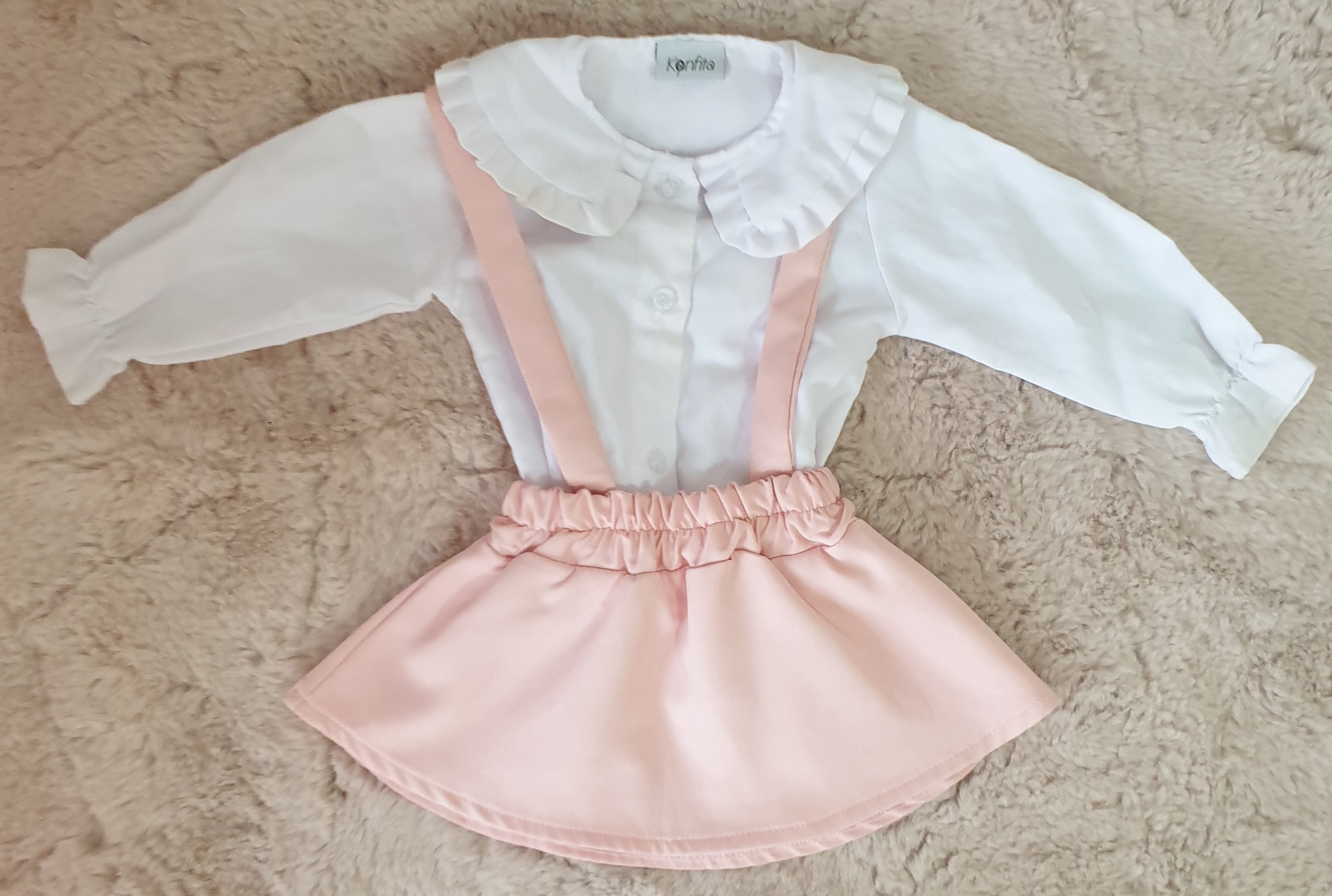 jupe à bretelles rose avec une chemise blanche